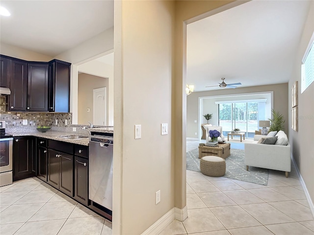 kitchen featuring light tile patterned floors, stainless steel appliances, tasteful backsplash, and sink