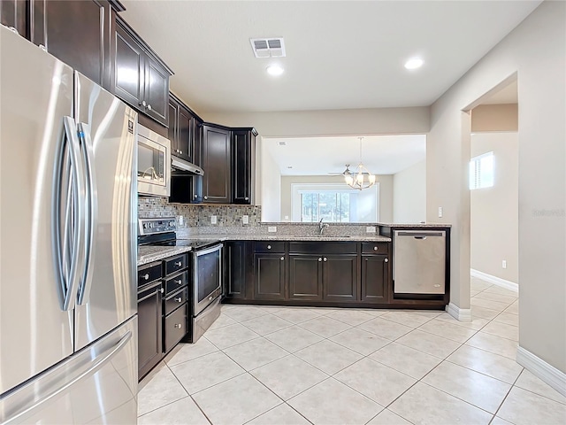 kitchen featuring sink, a chandelier, decorative backsplash, light tile patterned floors, and appliances with stainless steel finishes