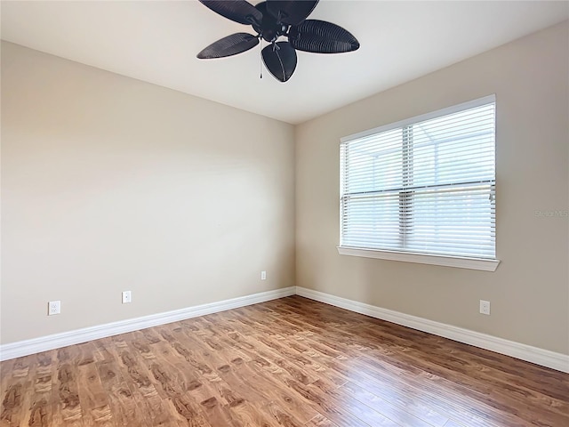 unfurnished room with ceiling fan, wood-type flooring, and a wealth of natural light