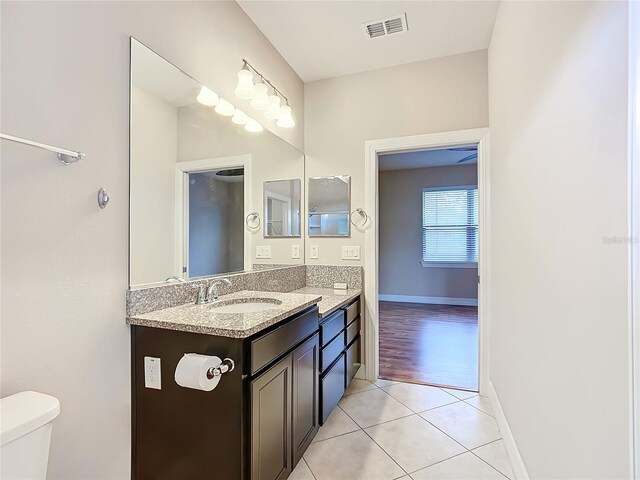 bathroom with tile patterned flooring, vanity, and toilet