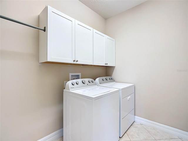 washroom featuring light tile patterned flooring, cabinets, and independent washer and dryer