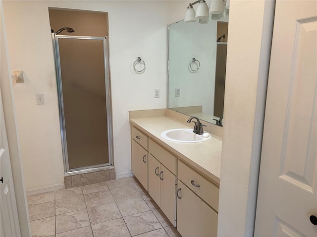 bathroom with a shower with door, vanity, and tile patterned flooring