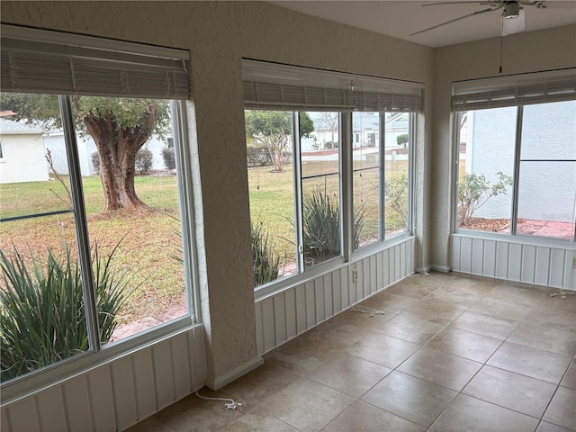 unfurnished sunroom featuring ceiling fan