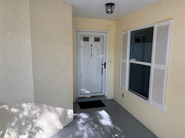 entrance to property with stucco siding