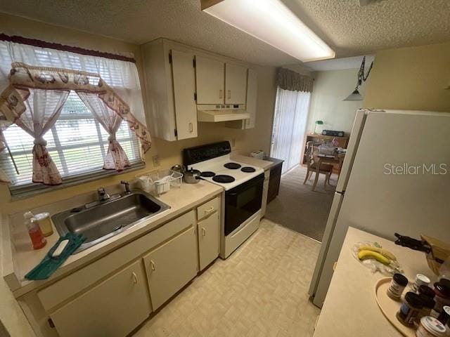 kitchen featuring a textured ceiling, white appliances, cream cabinets, and sink