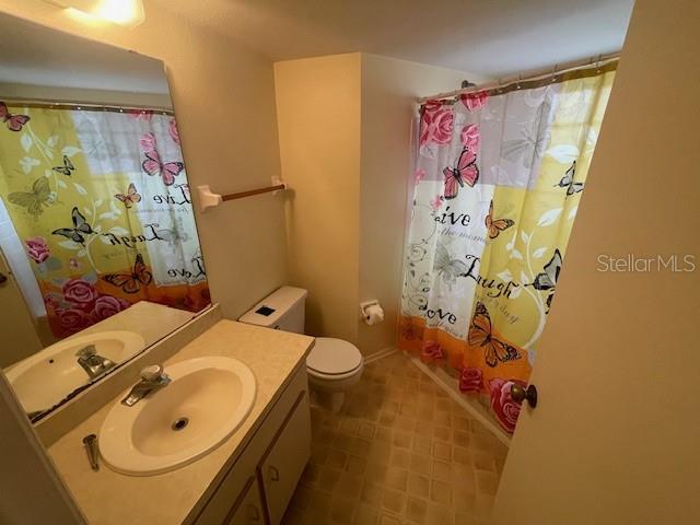 bathroom with a shower with curtain, vanity, and toilet