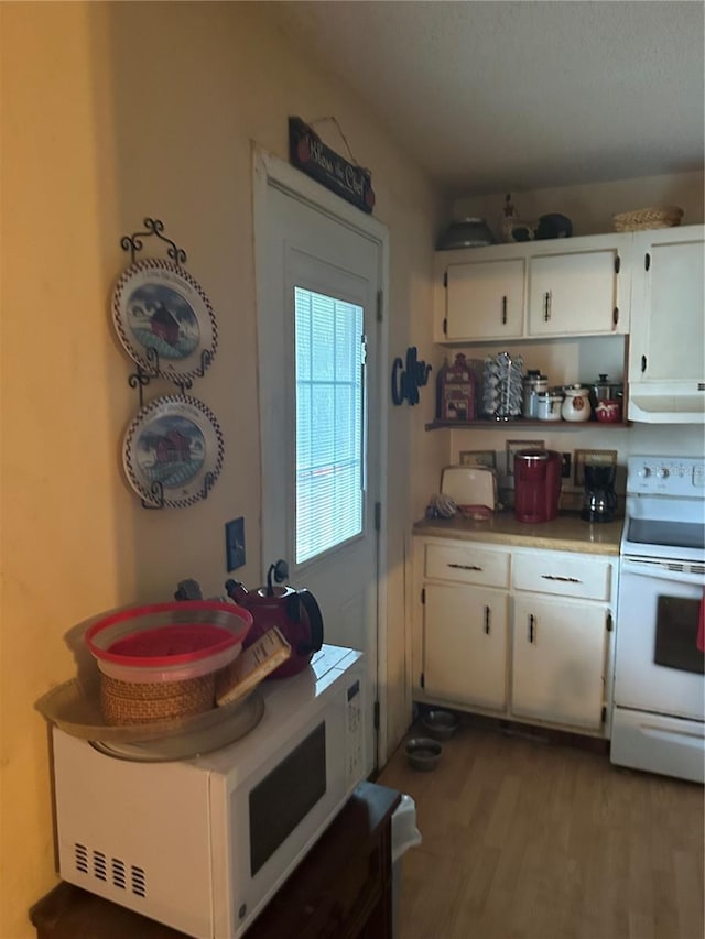 kitchen with white cabinetry, white appliances, extractor fan, and light hardwood / wood-style flooring