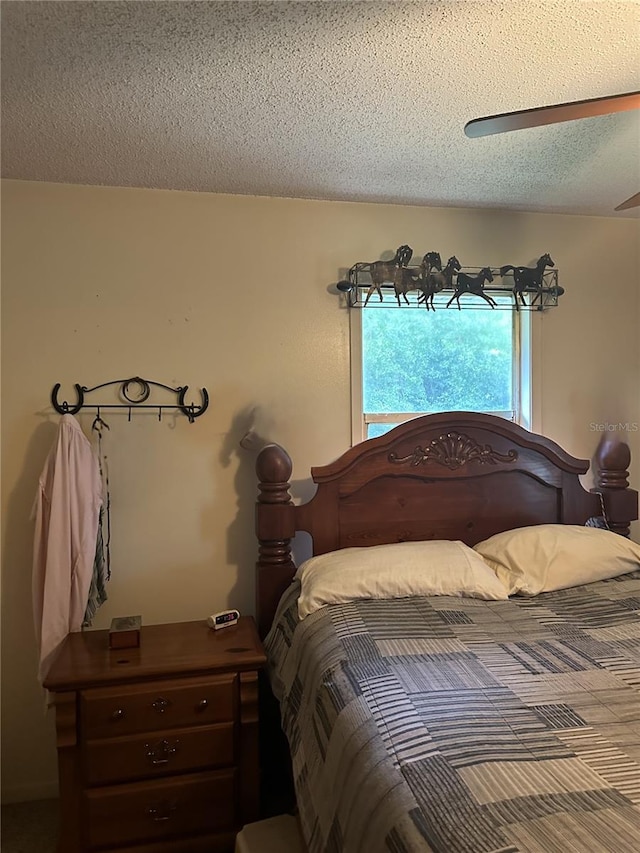 bedroom with ceiling fan and a textured ceiling