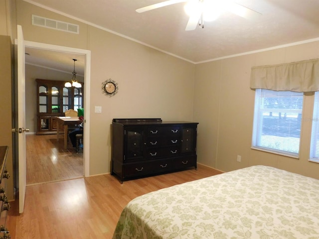 bedroom featuring hardwood / wood-style floors, vaulted ceiling, ceiling fan, and crown molding