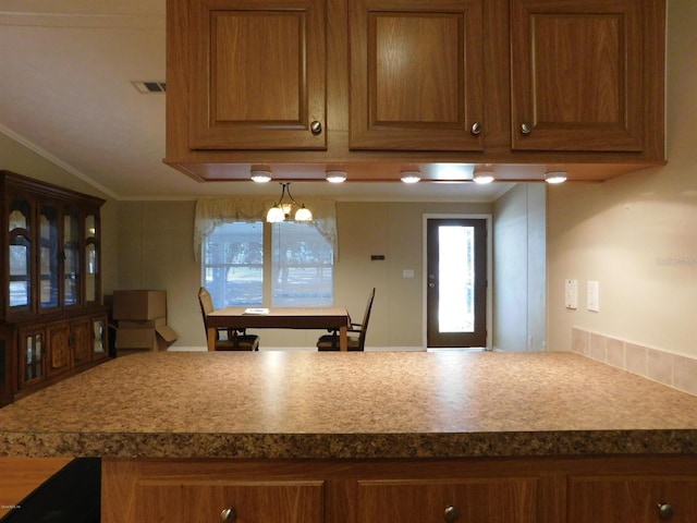 kitchen with a notable chandelier, crown molding, and vaulted ceiling