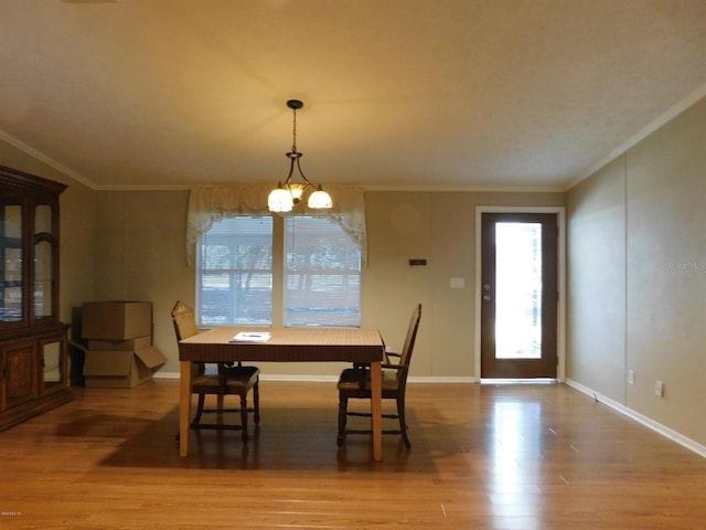 dining room featuring hardwood / wood-style floors, ornamental molding, and a notable chandelier