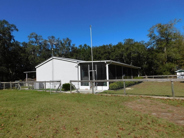 back of property with a sunroom and a yard