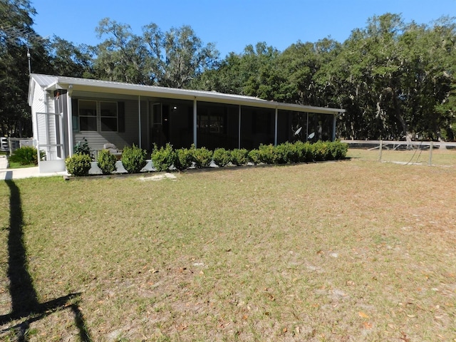 view of front of property with a sunroom and a front yard