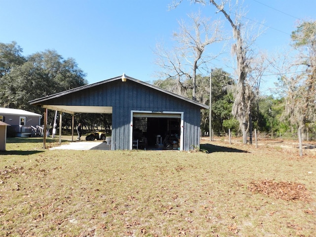 view of outbuilding with a yard, a garage, and a carport