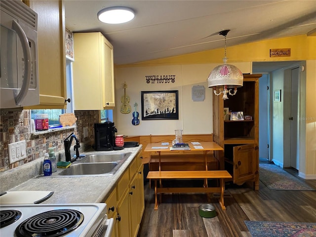 kitchen featuring backsplash, vaulted ceiling, dark wood-type flooring, sink, and pendant lighting