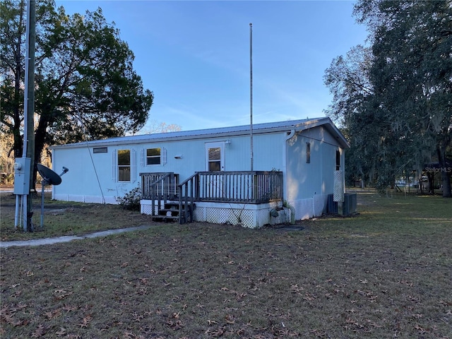 manufactured / mobile home with central AC, a front lawn, and a deck