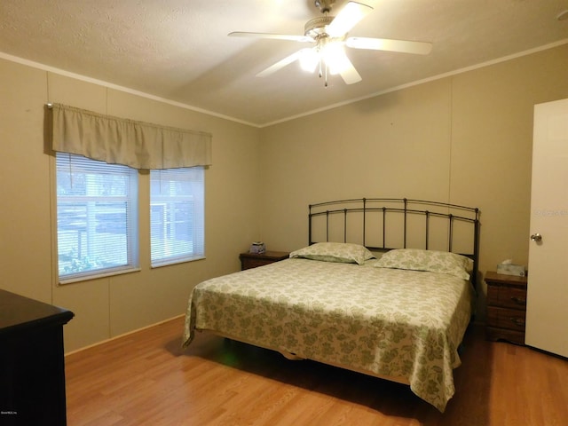 bedroom with wood-type flooring, ceiling fan, and crown molding