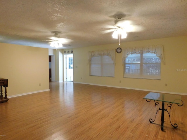 interior space featuring ceiling fan, a textured ceiling, and light wood-type flooring