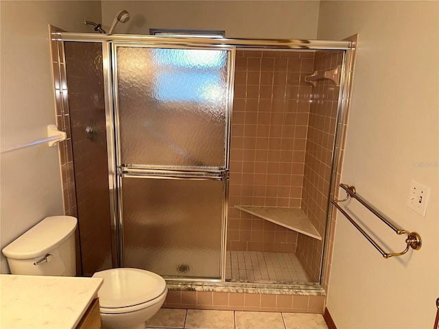 bathroom featuring tile patterned flooring, vanity, an enclosed shower, and toilet