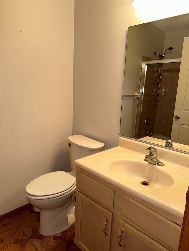 bathroom with vanity, toilet, and tiled shower