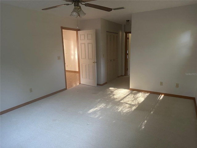 carpeted spare room featuring ceiling fan