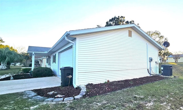 view of side of property featuring a garage and cooling unit