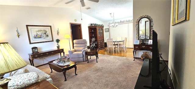 living area with carpet, a textured ceiling, ceiling fan with notable chandelier, and lofted ceiling