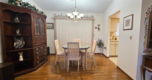 dining space with vaulted ceiling and an inviting chandelier