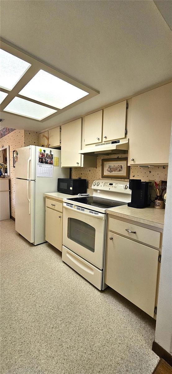 kitchen with cream cabinets and white appliances