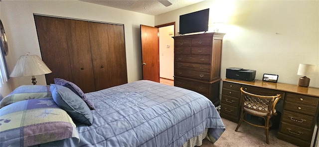 carpeted bedroom with ceiling fan, a closet, and a textured ceiling