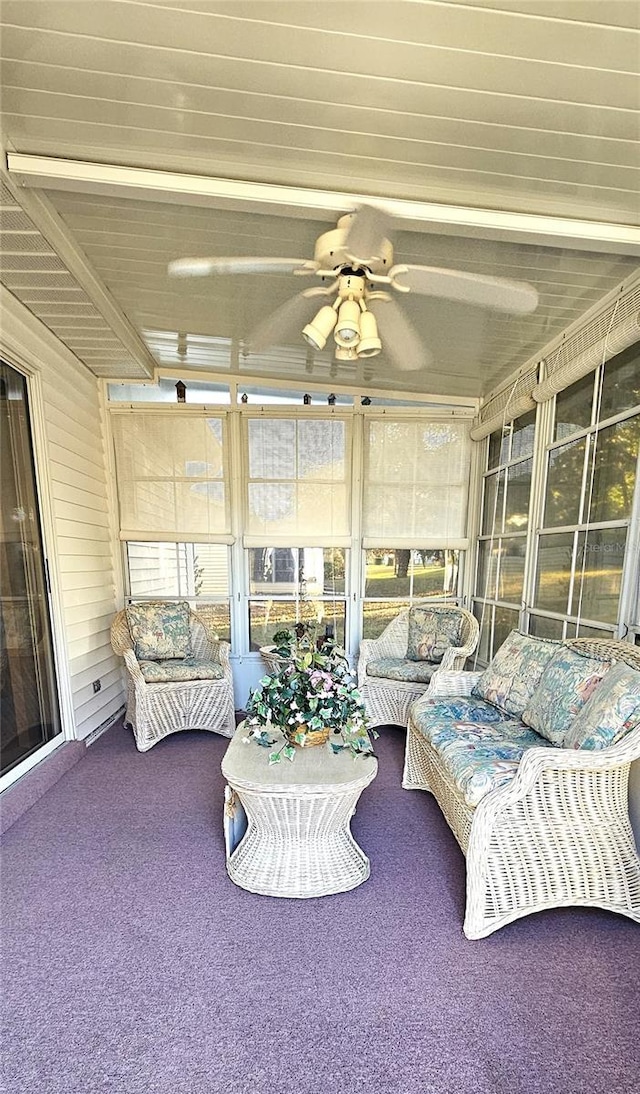 sunroom / solarium featuring beam ceiling and ceiling fan