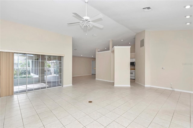 empty room with ceiling fan, light tile patterned floors, and vaulted ceiling