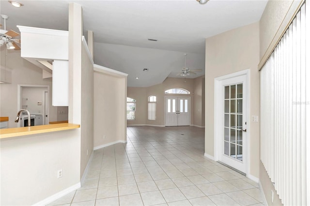 interior space featuring ceiling fan, light tile patterned floors, and high vaulted ceiling