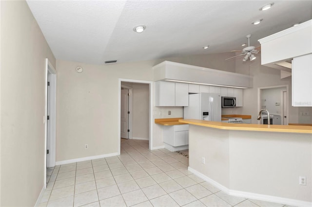 kitchen featuring white appliances, white cabinets, sink, vaulted ceiling, and ceiling fan