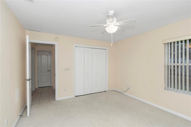 unfurnished bedroom featuring ceiling fan, light carpet, and a closet