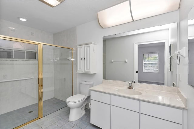 bathroom featuring tile patterned floors, vanity, toilet, and a shower with shower door