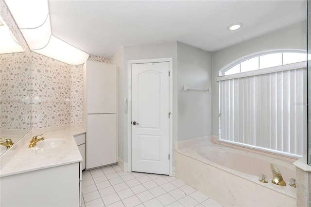 bathroom with tile patterned floors, vanity, and a tub to relax in