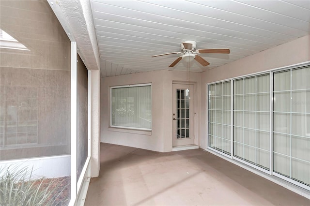 unfurnished sunroom featuring ceiling fan