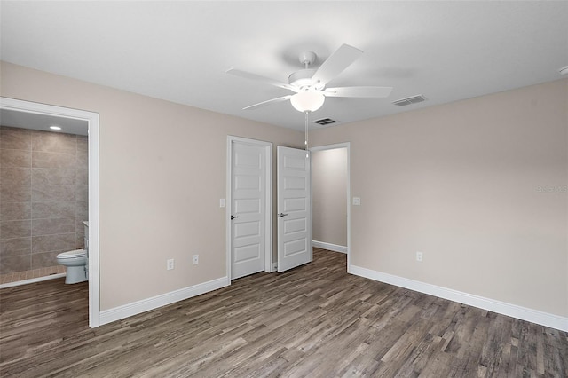 unfurnished bedroom with ceiling fan, a closet, wood-type flooring, and ensuite bath