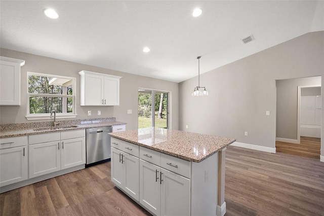 kitchen with dishwasher, sink, a kitchen island, pendant lighting, and white cabinets