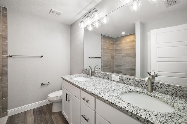 bathroom featuring vanity, a shower, toilet, a textured ceiling, and wood-type flooring