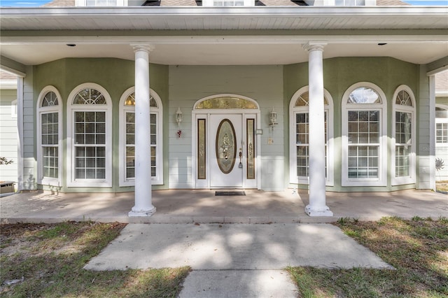 view of exterior entry with a porch