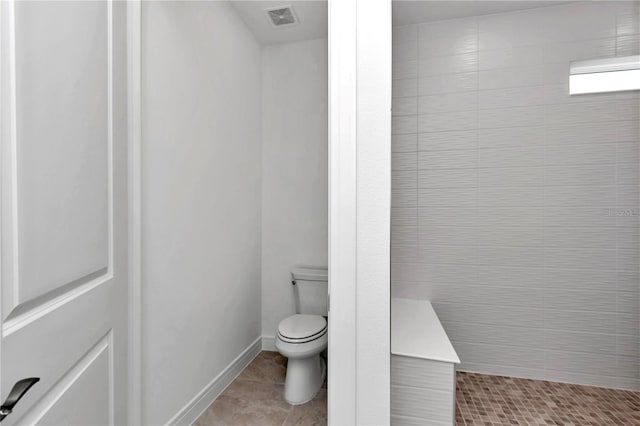 bathroom featuring tile patterned floors, a shower, and toilet