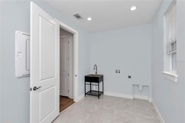 washroom with hookup for an electric dryer, hookup for a washing machine, sink, electric panel, and light tile patterned flooring