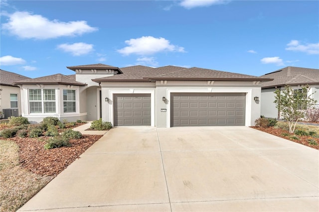 prairie-style home with cooling unit and a garage