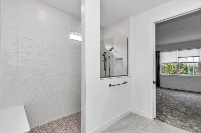 bathroom with tile patterned flooring and a tile shower