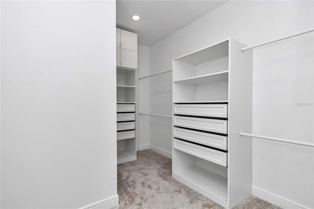 walk in closet featuring light colored carpet