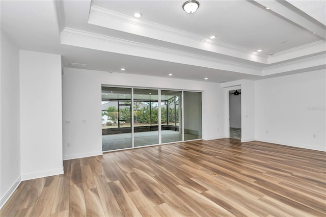 spare room featuring hardwood / wood-style floors, a raised ceiling, ceiling fan, and crown molding