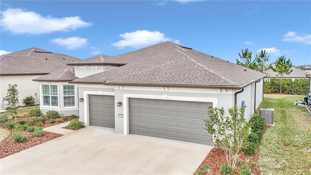 view of front of property with a garage, a front lawn, and central air condition unit