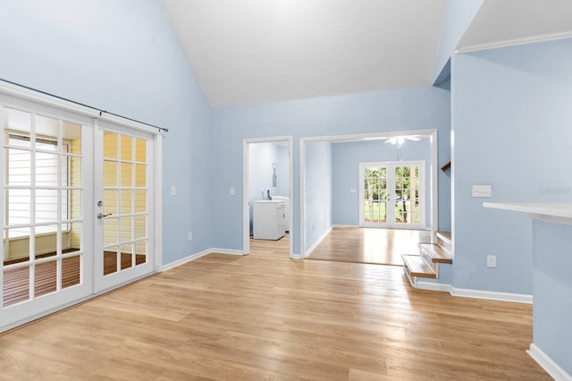 unfurnished living room with french doors, high vaulted ceiling, and light wood-type flooring